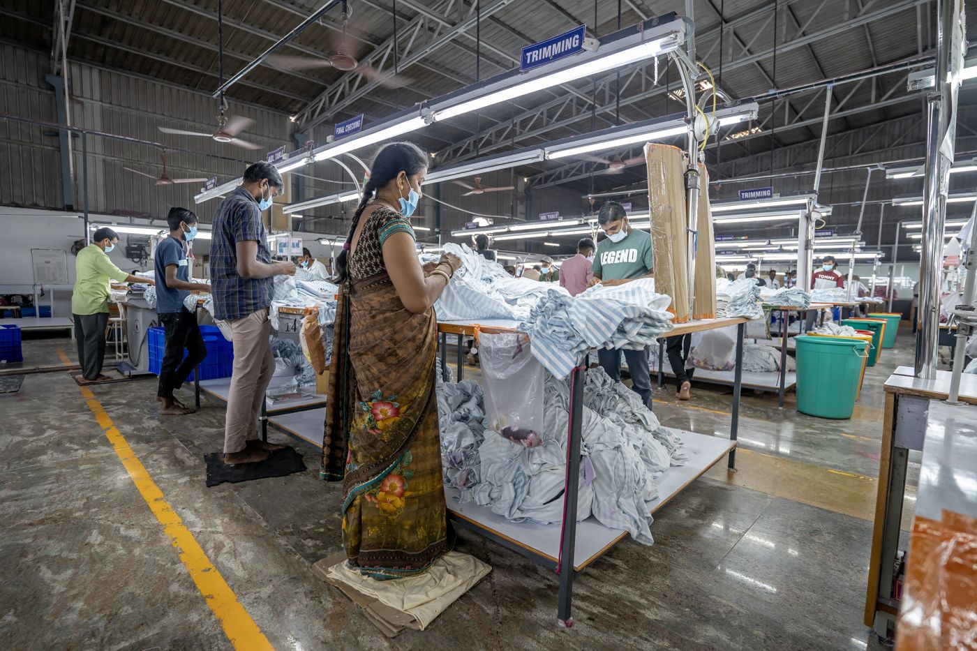 Garment production line with operators and trolleys